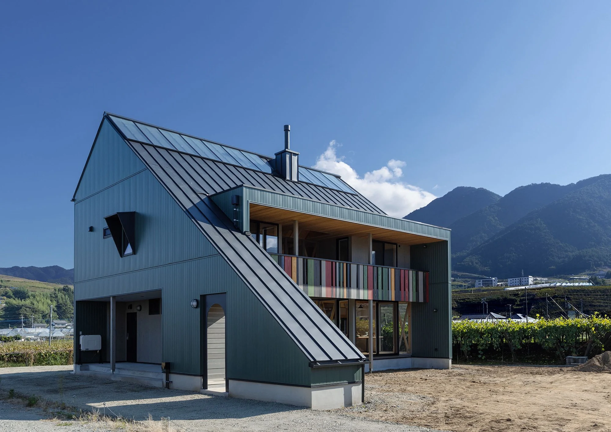 山々を背景にした、昼の外観。
