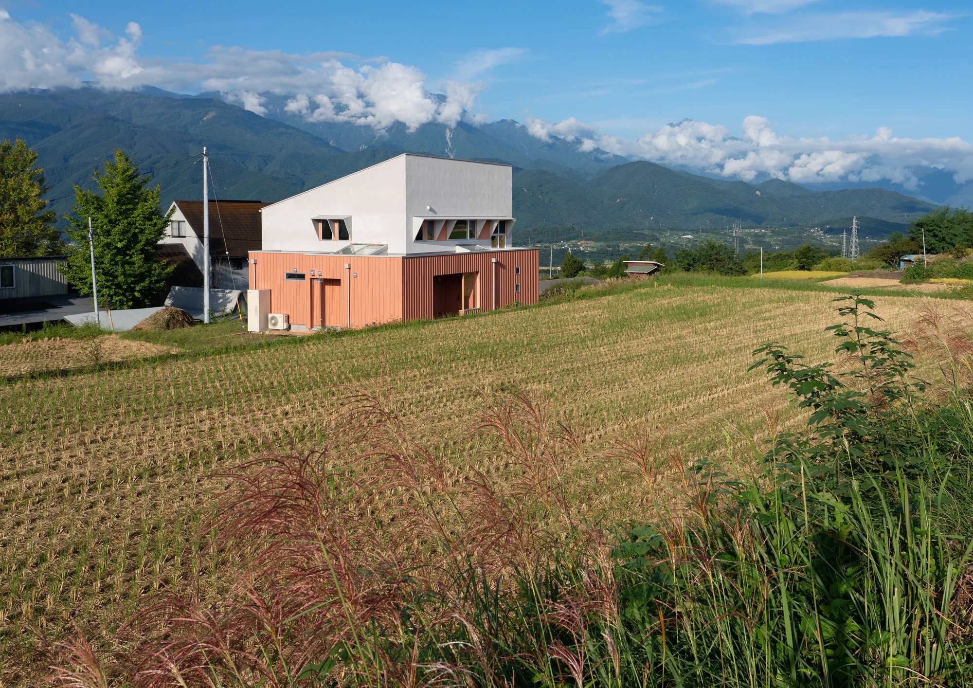 山々を背景に、畑のそばで暮らす。