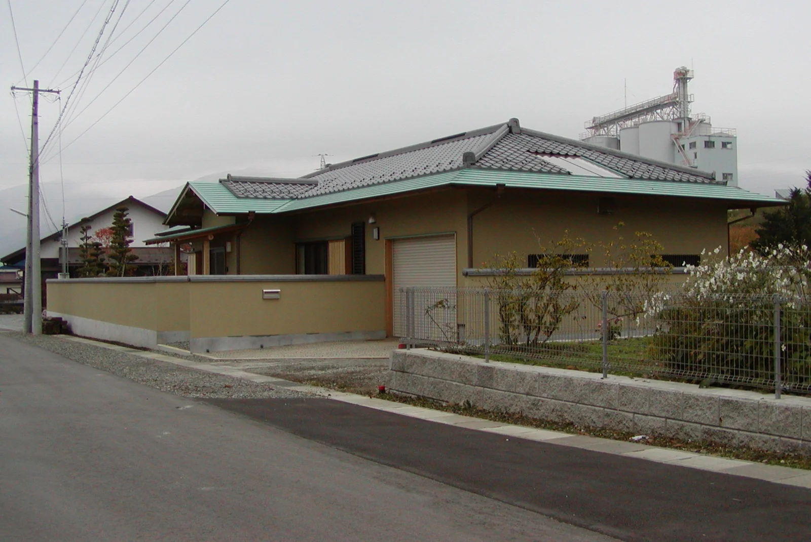 通りに面した塀と、ゆったりとした屋根。